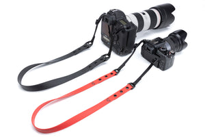 Henry & Sadie 1 Inch Onyx Black and 3/4 inch Red Camera Straps connected to cameras