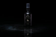 Load image into Gallery viewer, A dark bottle of Cedrat et Mandarine Room and Linen spray, standing on a reflective dark surface against a solid black background.